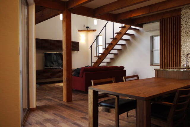 1階LDK。床は、ウォールナットを基調とする家具と素材を統一した。杉材や米松を用いた梁や柱の構造材もその色合いに合わせて着色し、全体的なバランスを考慮した。他にも壁と天井は全て漆喰で仕上げるなど、ほぼ全て自然素材が使用された贅沢な内部空間だ