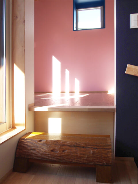２階の寝室の壁の一部は、映画で最も幸せだったシーンのピンク色を再現。寝室の段差のステップには、旧家の上がり框の木材を再利用することで、想い出を繋いだ
（撮影：バノラボ）