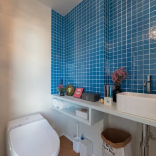 鮮やかなブルーのタイルが貼られたトイレ、今は漫画や雑誌が置いてあって、こもり場所になっているそう