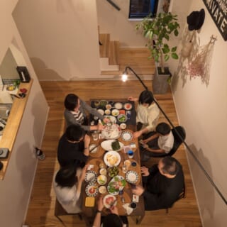 小林さん片岡さんも招かれた食事会。白壁に反射する照明の光が美しい。テーブルの上に伸びる照明は、ジャン・プルーヴェのウォールランプ