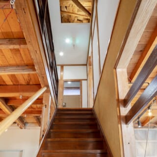 歴史を感じるあめ色の階段もそのまま使用。天井は一部を抜いて構造材を現し、梁型に沿って照明を仕込んだ