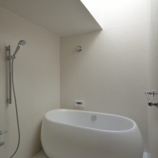浴室。要望から浴槽は置き型とした。外に開いていないため壁を白くし、天窓から光を入れて明るさを確保