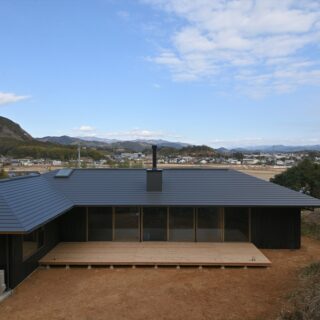 高い平地からの眺め。建物の高さが抑えられているため、家が邪魔にならずに視線が伸びていく。「この風景は絶対に生かしたいと考えました」と坪井さん。画像左側には隣家があるが、建物をL字型にすることで視線を遮り開放的な庭をつくった