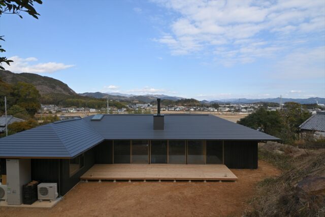 高い平地からの眺め。建物の高さが抑えられているため、家が邪魔にならずに視線が伸びていく。「この風景は絶対に生かしたいと考えました」と坪井さん。画像左側には隣家があるが、建物をL字型にすることで視線を遮り開放的な庭をつくった