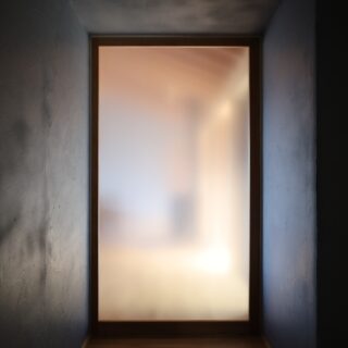 玄関とLDKの仕切り戸はすりガラスに。漆喰にぼんやりとした光が当たり、表情豊かな空間となった