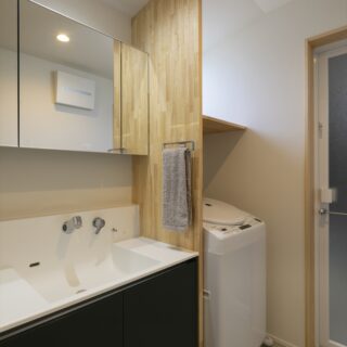 洗面室もフレキシブルボードを使い、シンプルながら温かな雰囲気に。ほかのスペースとの統一感を生んでいる