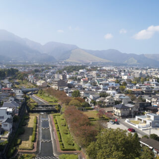 house-Nの東側から俯瞰。目の前に流れる川の両岸は砂防公園として整備され、桜並木が植樹されている。奥に見えるのは鶴見連山の山々。この素晴らしいロケーションを最大限に楽しめるようプランニング