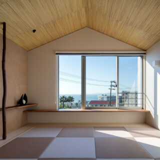 2階和室は、旅行会社を経営するオーナーから「布団が敷ける場所があったほうが、使い方の可能性が広がる」と提案を受け設けた。サンセットを楽しむ場所でもあるため、窓際に腰掛けられるようになっている。左壁面の壁は、皆で京都まで出向き選んだ和紙を張り合わせた
