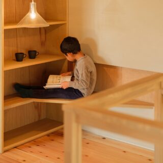 階段上にある読書コーナー。一番下は、ベンチのように腰掛けてもよし、机として利用してもよし。１つの造作に２つの機能を持たせる手腕は見事
