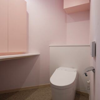 キッチンに合わせ、トイレもピンクを基調に。写真左下は猫のトイレ置き場。上部の窓は猫窓