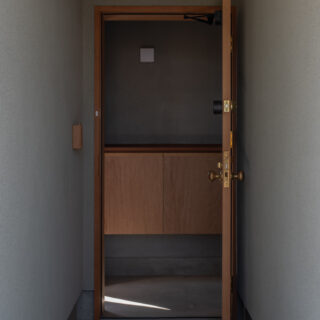 ポーチから玄関を見る。日本らしい、しっとりした空気が感じられる。左壁面にはスマートキー収納小箱がある