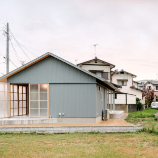 外観。「倉庫のような家」という要望を、ガルバリウム鋼板とポリカーボネート板の外壁で表現した。そっけなくなりすぎないようにと軒裏の木目のディテールや、家をぐるりと一周するラインを施すなどデザイン性が高められており、前を通る人の目を引く