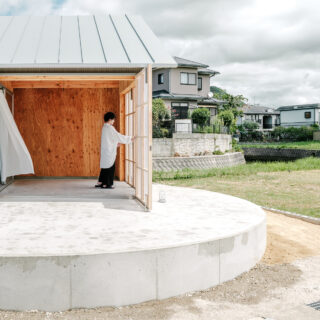 外観。建物の形は横長でシャープだが、川の流れと円形のテラスのラインがリフレインして柔らかな印象の家となった