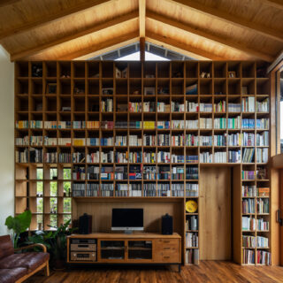 リビングの壁には、天井近くまで続く本棚。まるで図書館のよう。光の取り込み方を工夫することで、圧迫感のない空間となっている。