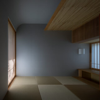 光の陰影が美しい和室。天井は、丸みをつけ葭束をあしらった。朱色のアクセントが映える京唐紙のふすま紙には、光の具合で銀色に輝く山桐の紋様が。