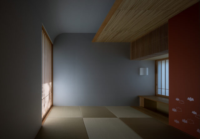 光の陰影が美しい和室。天井は、丸みをつけ葭束をあしらった。朱色のアクセントが映える京唐紙のふすま紙には、光の具合で銀色に輝く山桐の紋様が。

