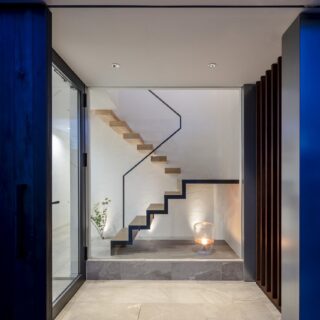 玄関ポーチに入るとアートのような階段が。浮遊感のある踏板、すうっと伸びた細い手すりのデザインが秀逸