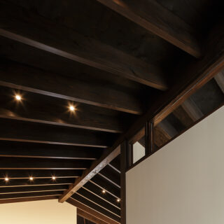 2階LDKの天井は屋根の形状を生かした。古色塗装された梁がリズミカルに並ぶ、ダイナミックな空間