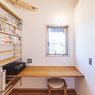 2 階、コンパクトで使いやすい書斎。壁面の本棚は収納力抜群。山桜を用いたカウンターに はゆとりがある