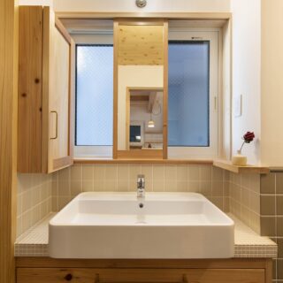 洗面台も藤田さんがデザイン。窓があり風通しも良い。鏡はレールで動かせるので、好きな位置で使える
