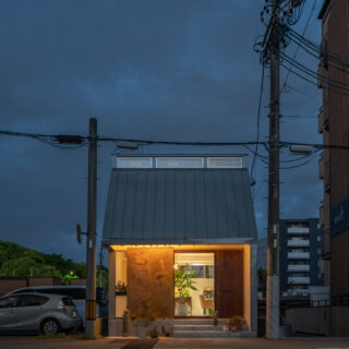 夜の外観。旧街道に温かい灯がぽつんと灯り、街に溶け込みながらも存在感を放っている
