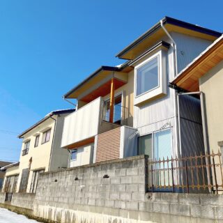 写真中央の建物が増築部分の狩野邸。写真右端の建物が実家部分。外壁に凹凸をつけることで、プライバシーを確保しながら光や風を導き、様々な窓辺の居場所を創り出した。