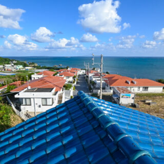 空と海に映える屋根の青い瓦は特注品。家から海へと続くリゾート分譲地の赤瓦との対比も心憎い