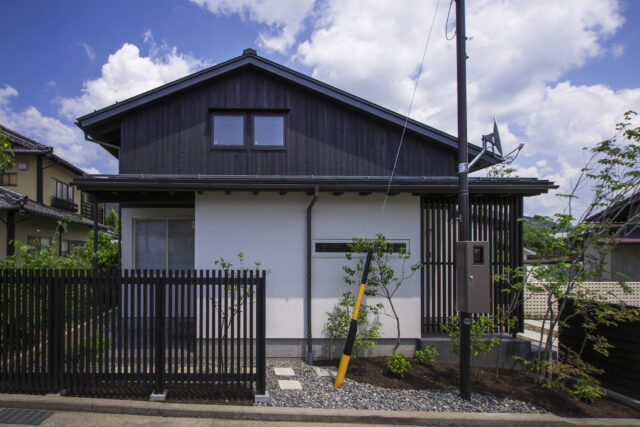 それぞれの屋根がつくる表情 − 2階を北側（写真左）に寄せることで、南側（写真右）の軒先が低くなる仕掛けが見て取れる。2階は屋根裏部屋のように見えるが目の錯覚を利用したもので、実際には問題のない室内高を確保している