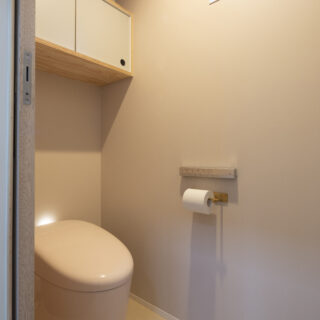 トイレの壁は淡いピンク。洗面室など生活空間以外の場所は、空間ごとにほんのり壁の色味を変えている