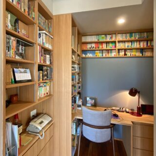 Hさんの蔵書の一部を保管できる書斎は、大人の隠れ家のよう。グレーの壁の反対側は扉の収納部となっており、その上部を活かし文庫本の本棚とした。