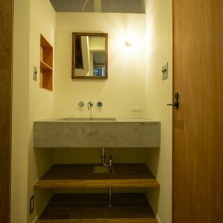 洗面。右の扉はトイレ。左には収納がある。帰宅して手を洗い、着替えて居室へという動線をデザインした