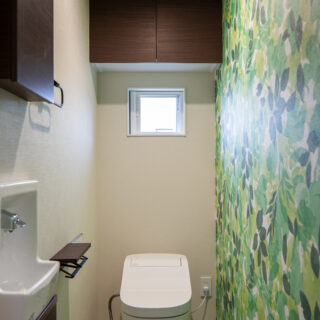 3階トイレ。アクセントとした壁紙に合わせ、床の色もほんのりしたグリーンを選んだ
