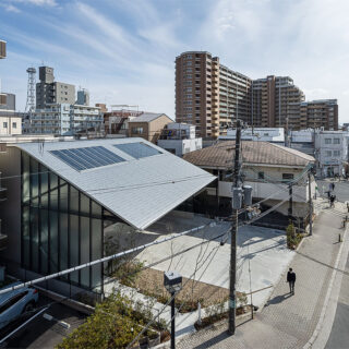 新旧の住宅が混在する地域に佇む、大屋根が特徴的な社屋。大屋根は大通りからも視認でき、アイキャッチとなっている
