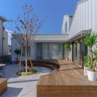 アウターリビング。建物の南側に配することで、右側のリビングにも日差しが入る。リビングの建具を開放すると、同じ高さのアウターリビングとつながる。大人数の来客が来ても、対応可能だ。アウターリビングは腰掛けられる高さに設計されている