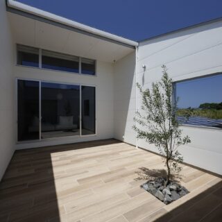 中庭は壁で囲い、高いプライバシー性を確保。太陽光パネルが設置され今後も家が建たないと見込まれた東側に窓を設け、閉塞感をなくした。南からの光が豊かに入り、風も抜けるおかげで、居心地は抜群。床面は木目調のタイルを採用。水に強くメンテナンスがしやすいメリットがある