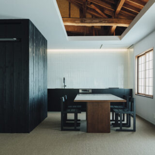 リビングから見たダイニング・キッチン方向。既存の天井の一部を開口部とし、立派な小屋裏を見せる。障子は既存の桟を活用。床は肌触りが良いサイザル麻カーペットを採用した