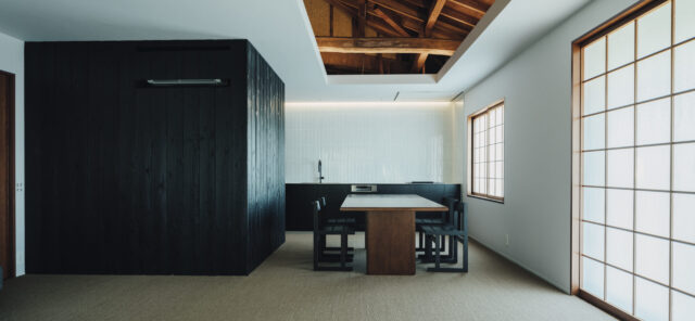 リビングから見たダイニング・キッチン方向。既存の天井の一部を開口部とし、立派な小屋裏を見せる。障子は既存の桟を活用。床は肌触りが良いサイザル麻カーペットを採用した