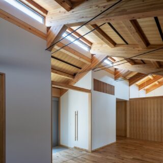 親世帯の玄関ホール。写真奥は主寝室で、上部はFIXのガラス窓で仕切られている。天井が続いているのが見えて広さや開放感が強調されるが、生活音や暑さ寒さはシャットアウトしてくれる
