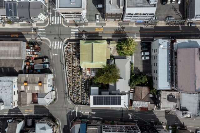 大阪市内にある浄土真宗大谷派 長源寺を空から撮影。太陽光のパネルを載せているのが庫裏の子世帯、グレーの屋根がかかっているのが親世帯。2つの世帯はL字のプランで分かれているが、どちらも中庭の大きな桜を眺められる配置となっている