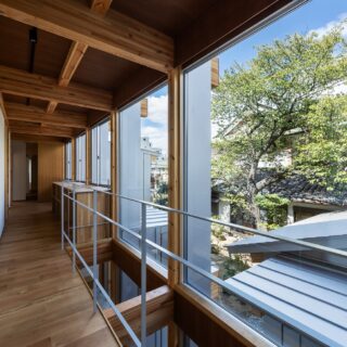 子世帯の2階の廊下も贅沢に窓を取った開放空間。廊下は幅を広めに取り、写真手前部分を1階とつながる吹抜けに。奥はカウンターデスク付きのワークスペースとして使えるようにしている。目の前に桜の木がある特等席だ