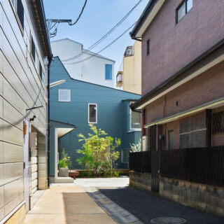 敷地は旗竿地。路地に入ったときに見えるのは一部分だが、屋根のユニークな形やグリーンの外壁が印象に残る