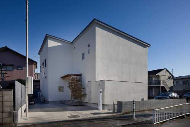 吹き付けの壁にガルバリウム鋼板の屋根をもつ外観。道路に面した西側は、プライバシー確保と西日を避けるため、窓を極力排した。