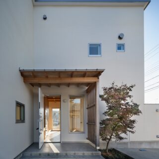 玄関には屋根をかけヒノキの梁と格子で「和」テイストを演出。シンボルツリーのもみじは、田辺さんとご主人とで植えたのだとか。