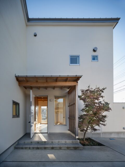 玄関には屋根をかけヒノキの梁と格子で「和」テイストを演出。シンボルツリーのもみじは、田辺さんとご主人とで植えたのだとか。