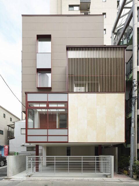 外観。異なる素材や色を組み合わせ、さらにアルミサッシなど既製品の使用を格子などで隠し意匠性を高めた
