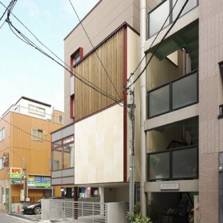 外観。2階左、赤さび色の枠はサンルーム、3階木製ルーバーはLDK脇のテラス。接道側からも採光を可能に