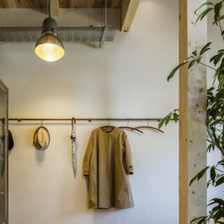 1階エントランスホール。簡素な仕上げで倉庫のような素っ気なさを演出した空間に、暖色系の照明やアンティークのアイテムがしっくりマッチ。いつものアウターをかけるだけで絵になる
