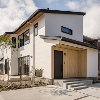 外観。住宅地にあり、周囲の景観になじむようシンプルな外観に。長年住む家なので、山本さんはあまり多くの色を使わないことが多いという。外構もすべて手掛け、奥にはかえで、手前にはブルーベリーを植えている。年月とともに植栽が成長する楽しみもある