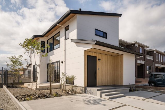 外観。住宅地にあり、周囲の景観になじむようシンプルな外観に。長年住む家なので、山本さんはあまり多くの色を使わないことが多いという。外構もすべて手掛け、奥にはかえで、手前にはブルーベリーを植えている。年月とともに植栽が成長する楽しみもある