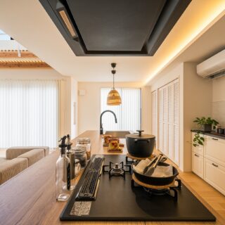 キッチンの木目を活かすため、後ろの壁はシンプルなホワイトに。間接照明を配し、空間もシンプルなものとした